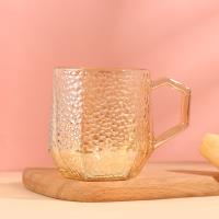 A hexagonal hammer-patterned cup with an amber color