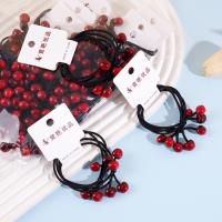 2 red cherry-shaped rubber bands with a string loop at each end