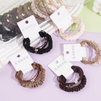 A set of three heart-shaped gold beads, featuring a delicate design, paired with a headband and elastic bands