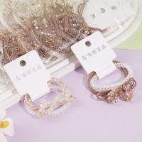 Un ensemble de cordon de téléphone en cristal avec un nœud papillon, un élastique pour cheveux et une pince à cheveux.