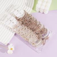 Un ensemble de cordon de téléphone en cristal avec un nœud papillon, un élastique pour cheveux et une pince à cheveux.