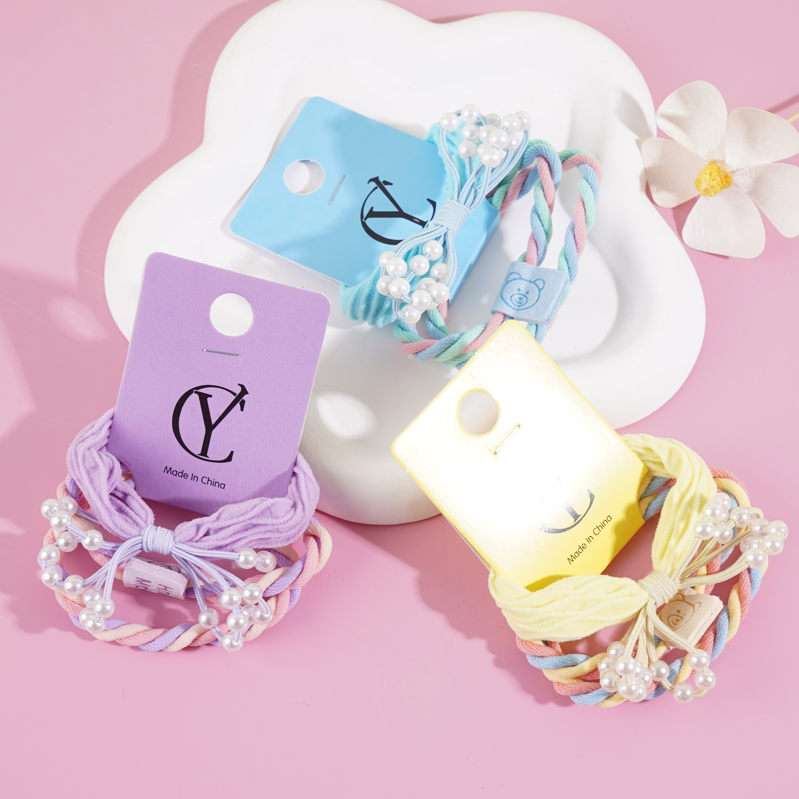 A set of three bow-shaped pearl headbands with elastic bands