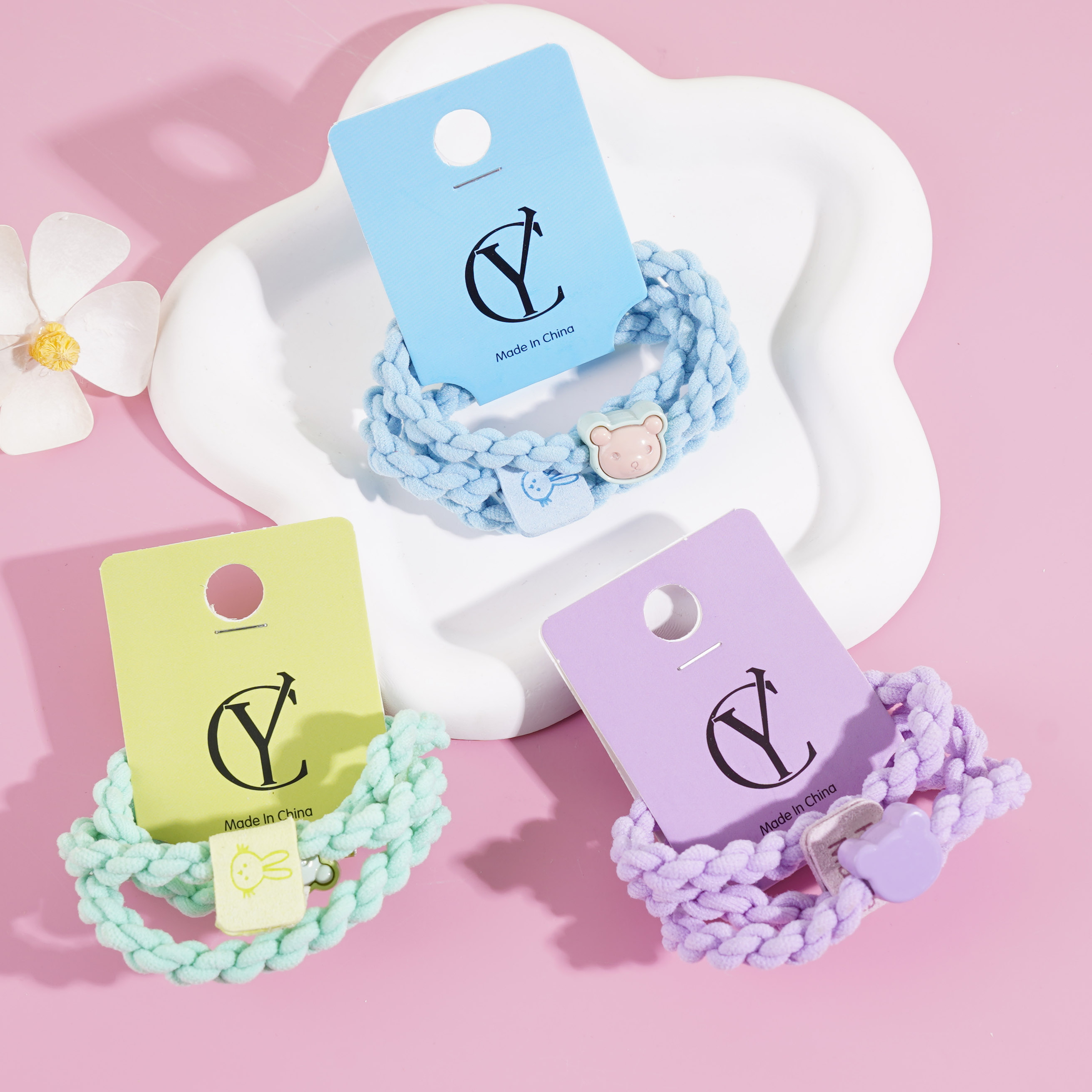 A set of three colorful bear-themed headbands and elastic bands