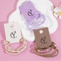 A set of three pearl-strung headbands and elastic bands