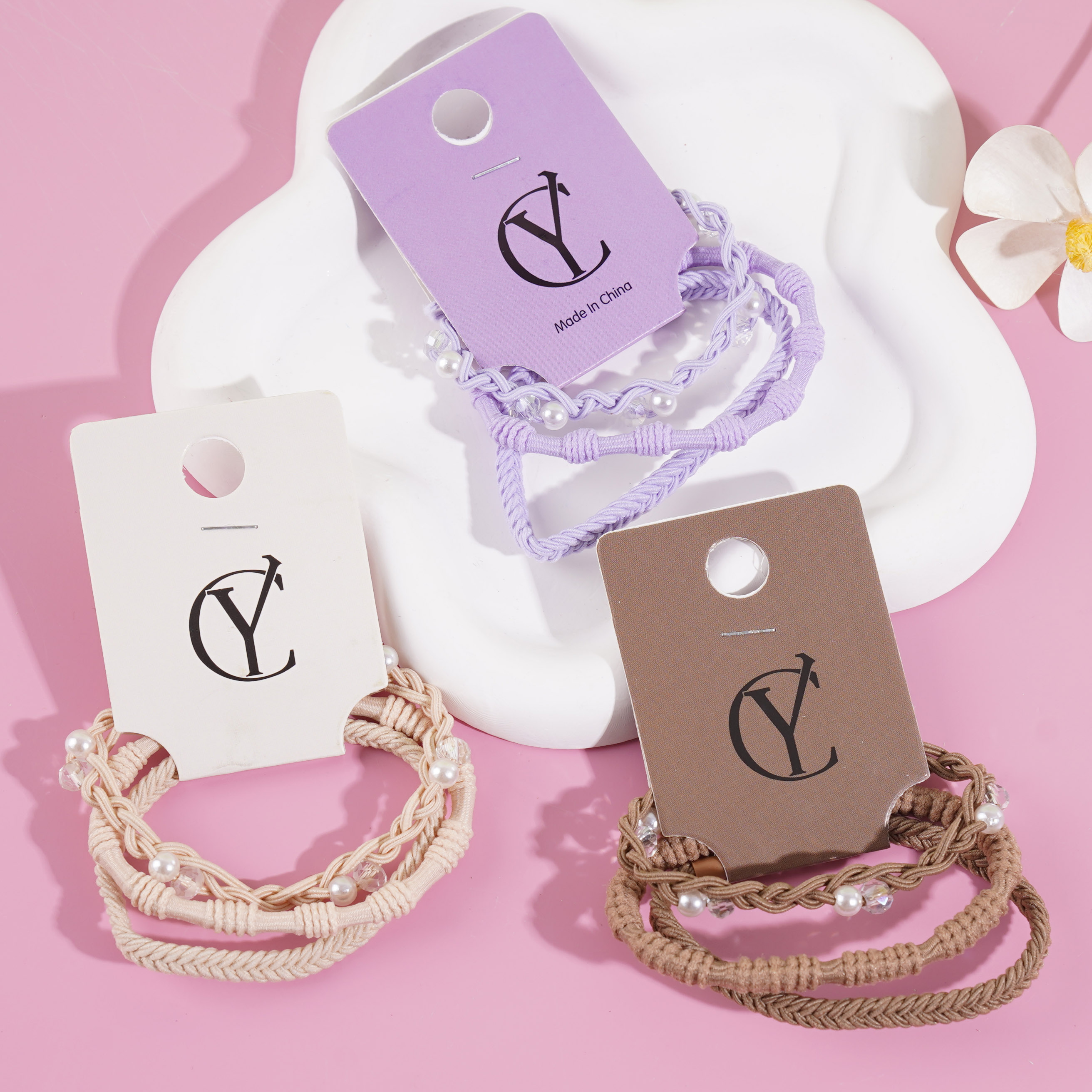 A set of three pearl-strung headbands and elastic bands