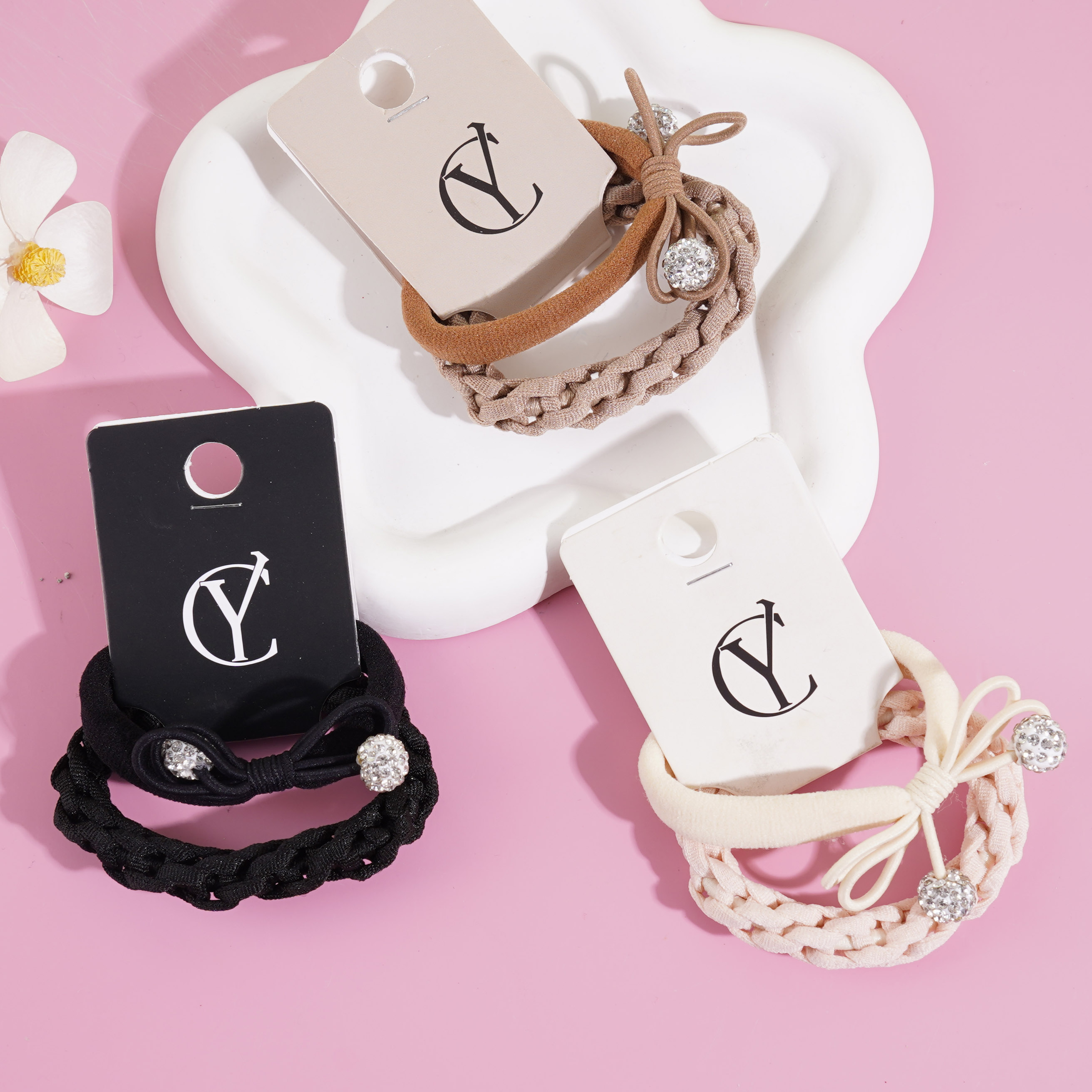 A set of two pearl and diamond bow-shaped headbands with elastic bands