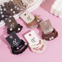 A set of two pearl and diamond bow-shaped headbands with elastic bands