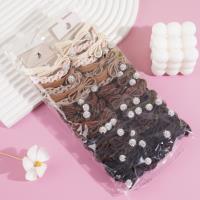 A set of two pearl and diamond bow-shaped headbands with elastic bands