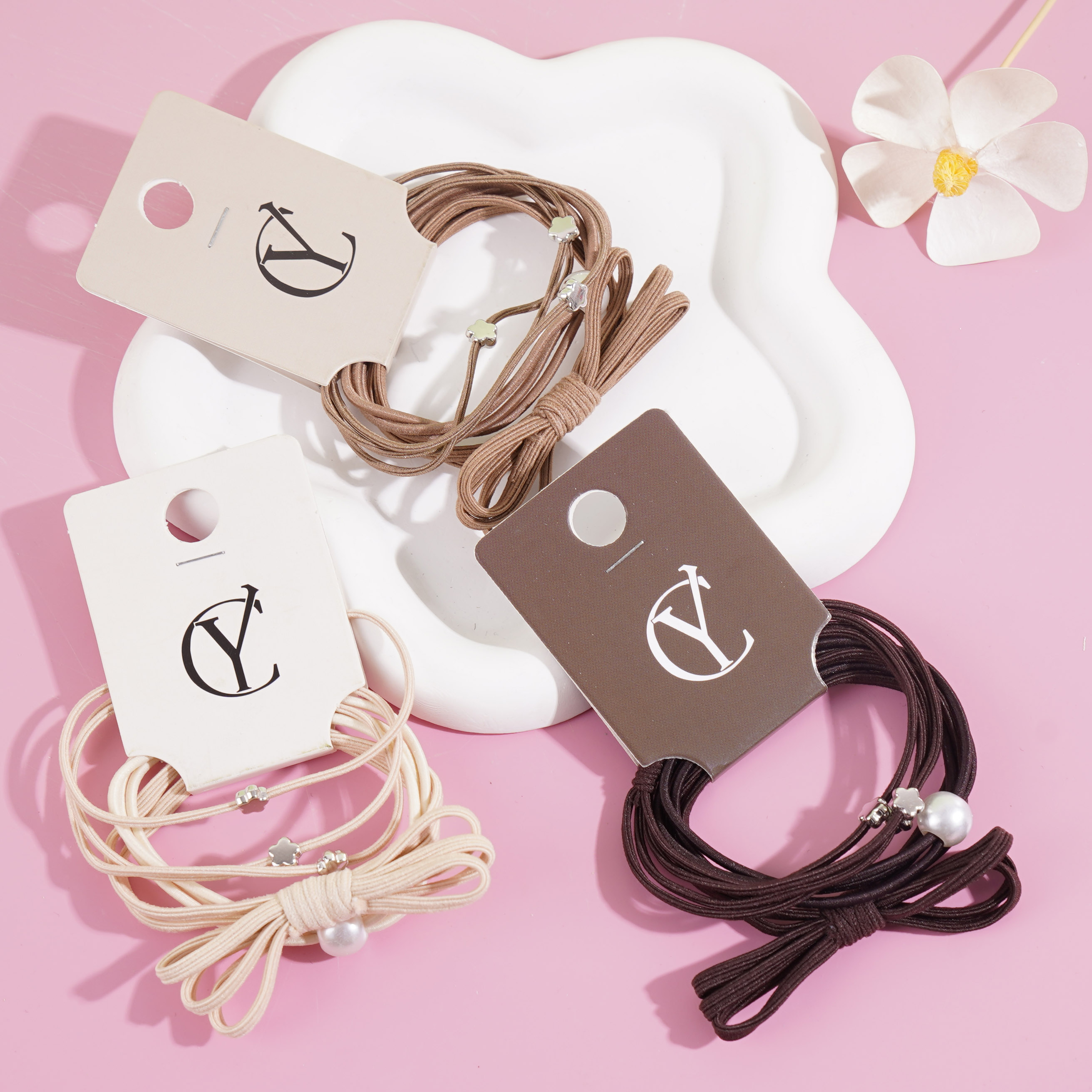 A set of three large pearl bow headbands with elastic bands