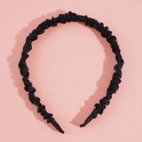 Une pince à cheveux plissée de couleur unie.