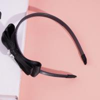 Une pince à cheveux en forme de nœud papillon, décorée de diamants et de perles.