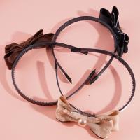 Une fermeture de cheveux avec un nœud papillon noir et un serre-tête en perles.