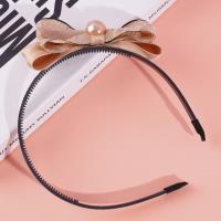 Une fermeture de cheveux avec un nœud papillon noir et un serre-tête en perles.