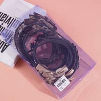 Une pince à cheveux avec un nœud à carreaux, une rose et un fermoir en diamant noir.