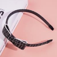 Une pince à cheveux avec une bordure en perles et un nœud en tête de cheval.