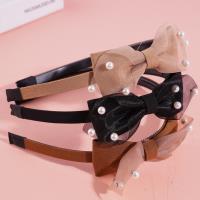 Un nœud papillon en dentelle avec une couronne de perles pour les cheveux.