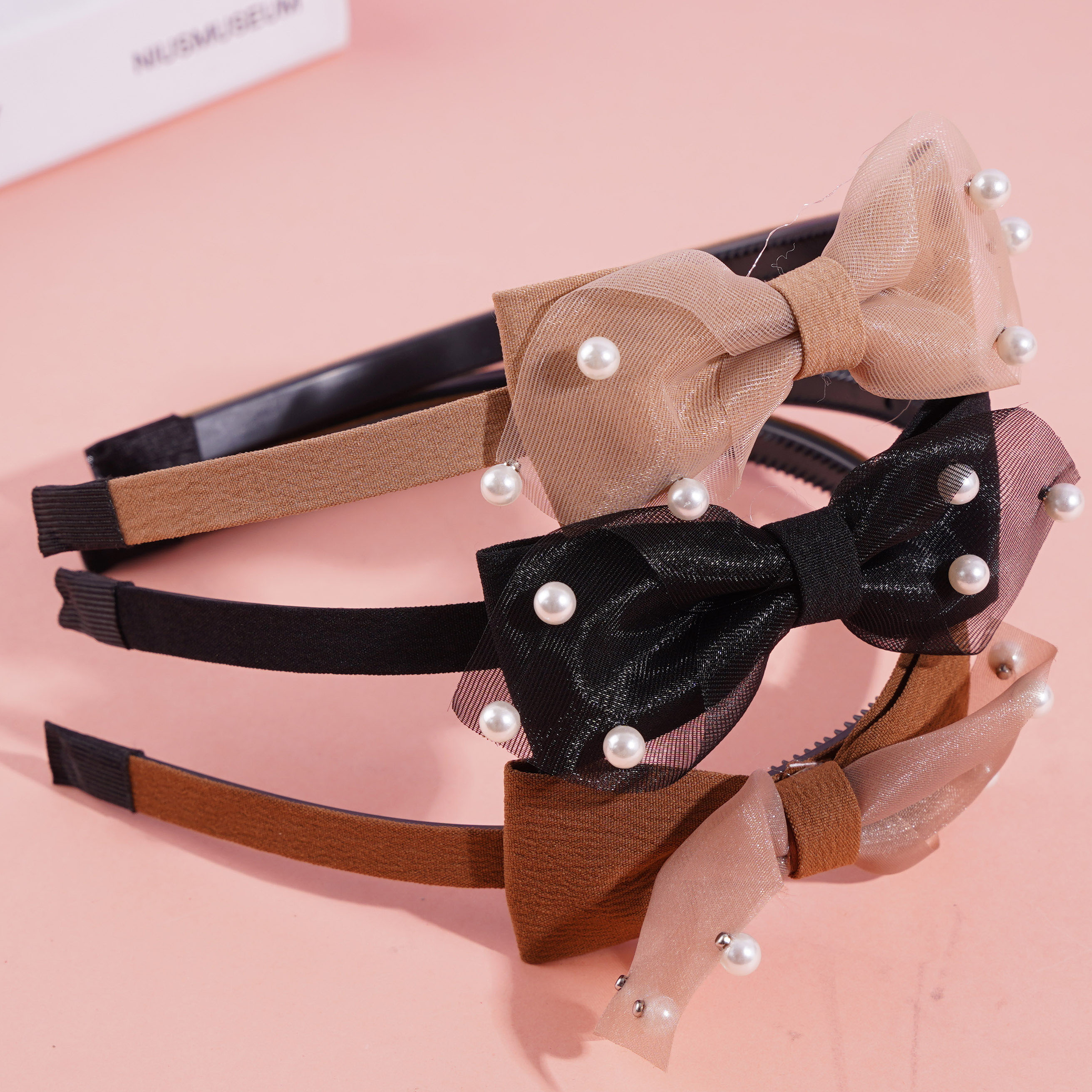 A lace bow tie with a pearl headband and a hair clip