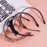 Un nœud papillon en dentelle avec une couronne de perles pour les cheveux.