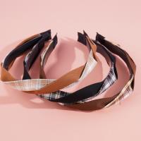 A large-checkered headband with a bow-shaped hair clip