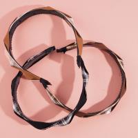 A large-checkered headband with a bow-shaped hair clip