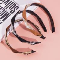 A large-checkered headband with a bow-shaped hair clip