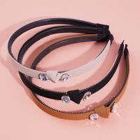 A dark-colored double-diamond headband buckle with a knotted design