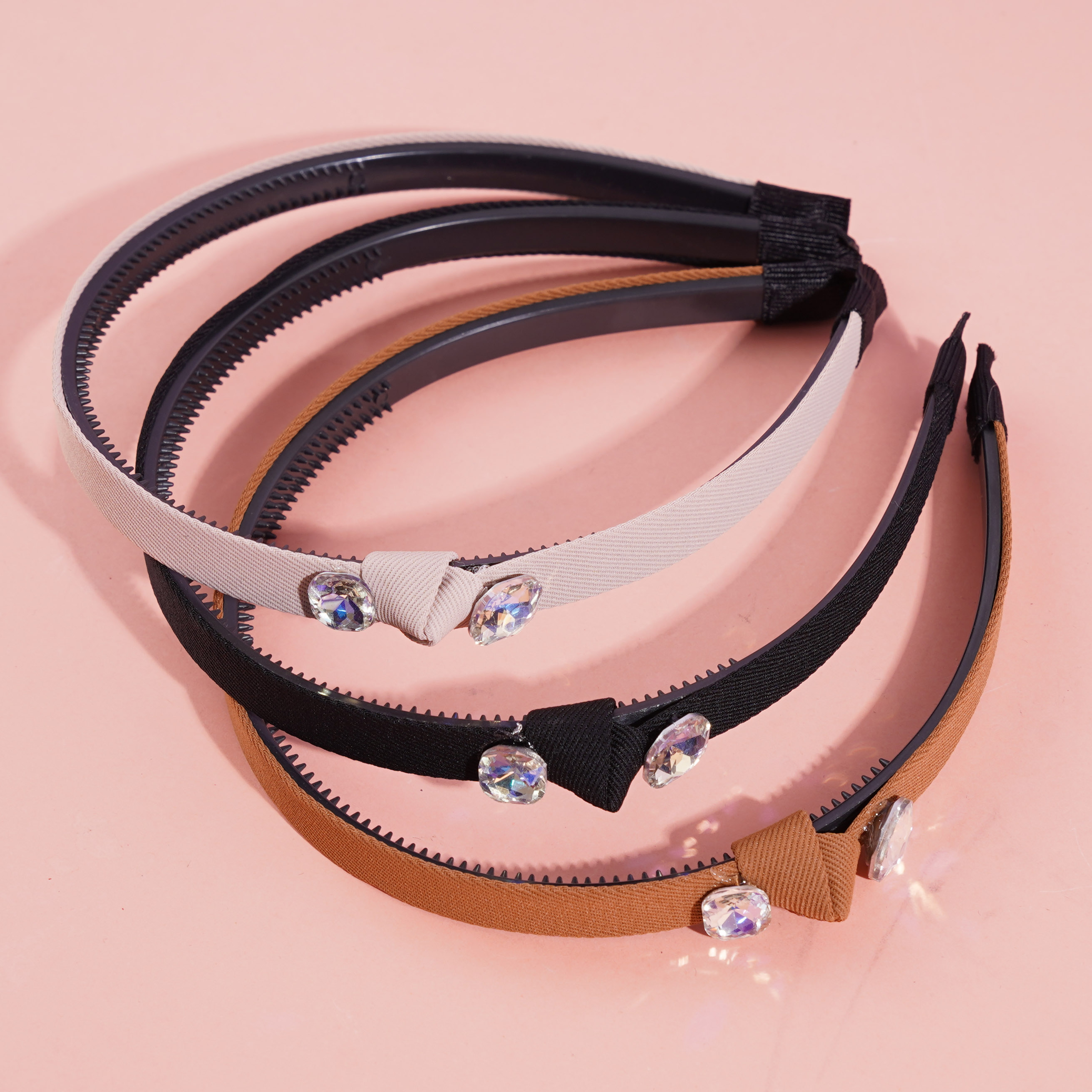 A dark-colored double-diamond headband buckle with a knotted design