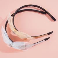 A children's headband with a bow made from checkered gauze and a hair clip