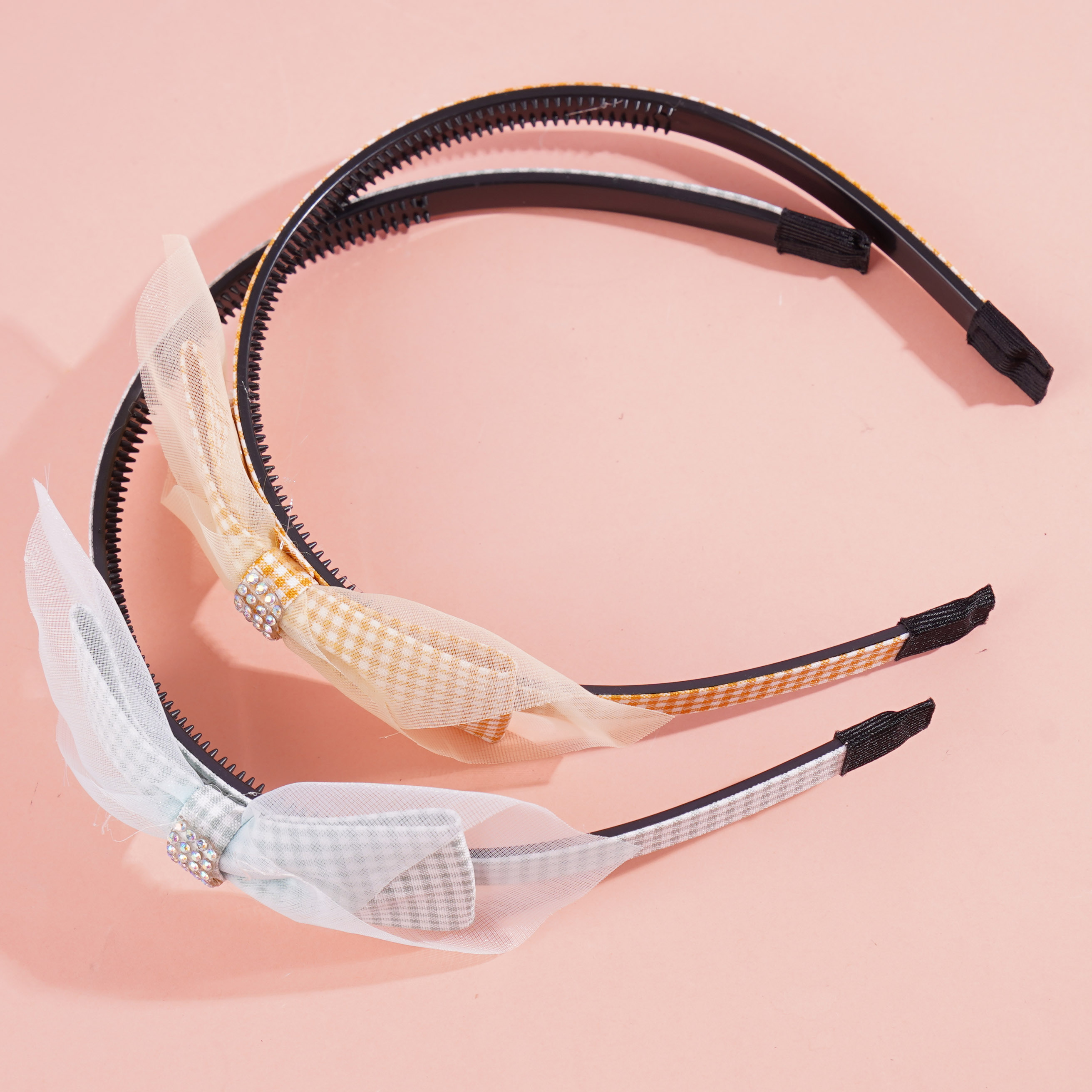 A children's headband with a bow made from checkered gauze and a hair clip