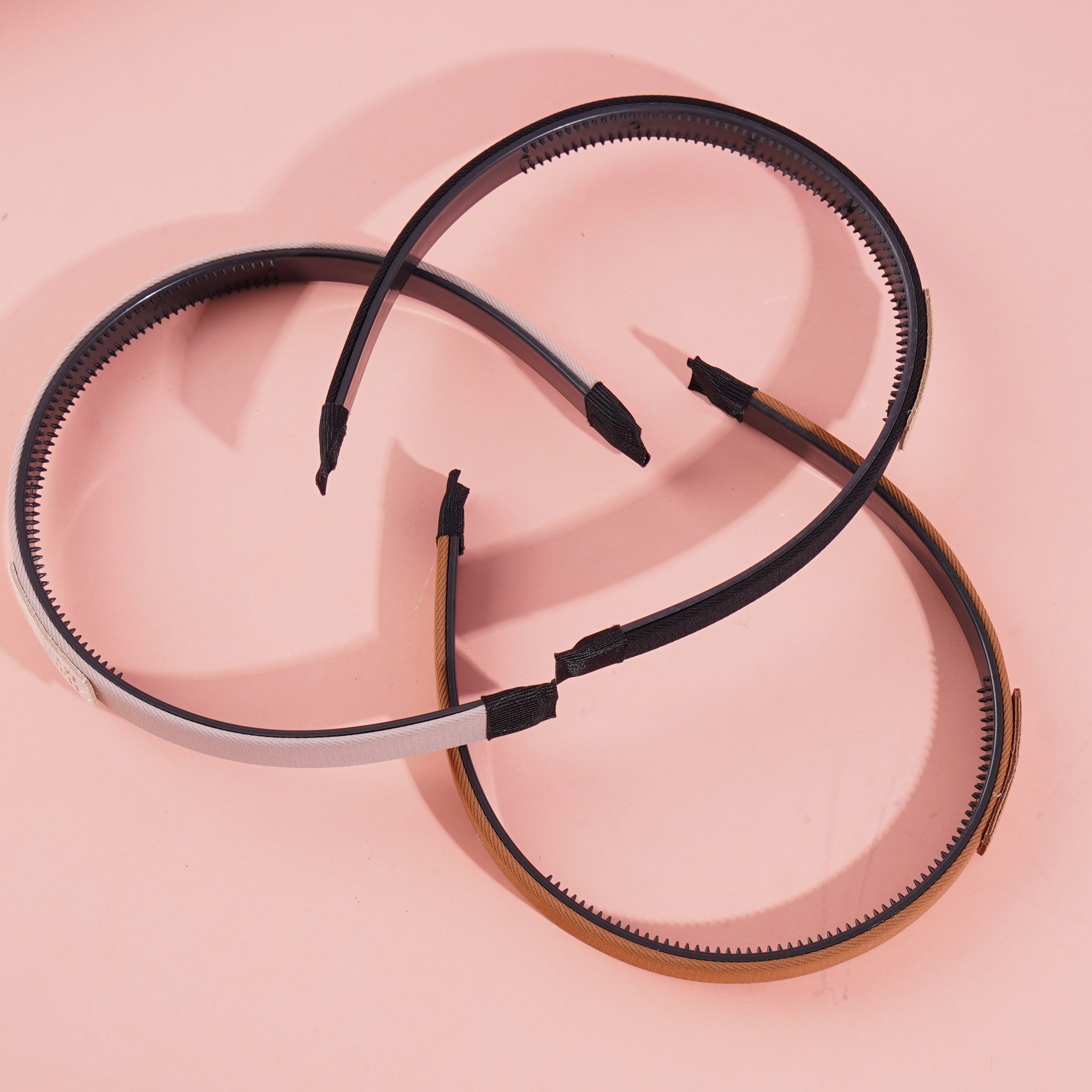 Dark-colored headband with a logo on it and a buckle for fastening the hair