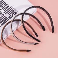 Dark-colored headband with a logo on it and a buckle for fastening the hair