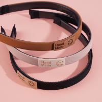 Dark-colored headband with a logo on it and a buckle for fastening the hair