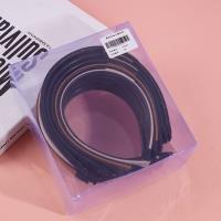 Dark-colored headband with a logo on it and a buckle for fastening the hair