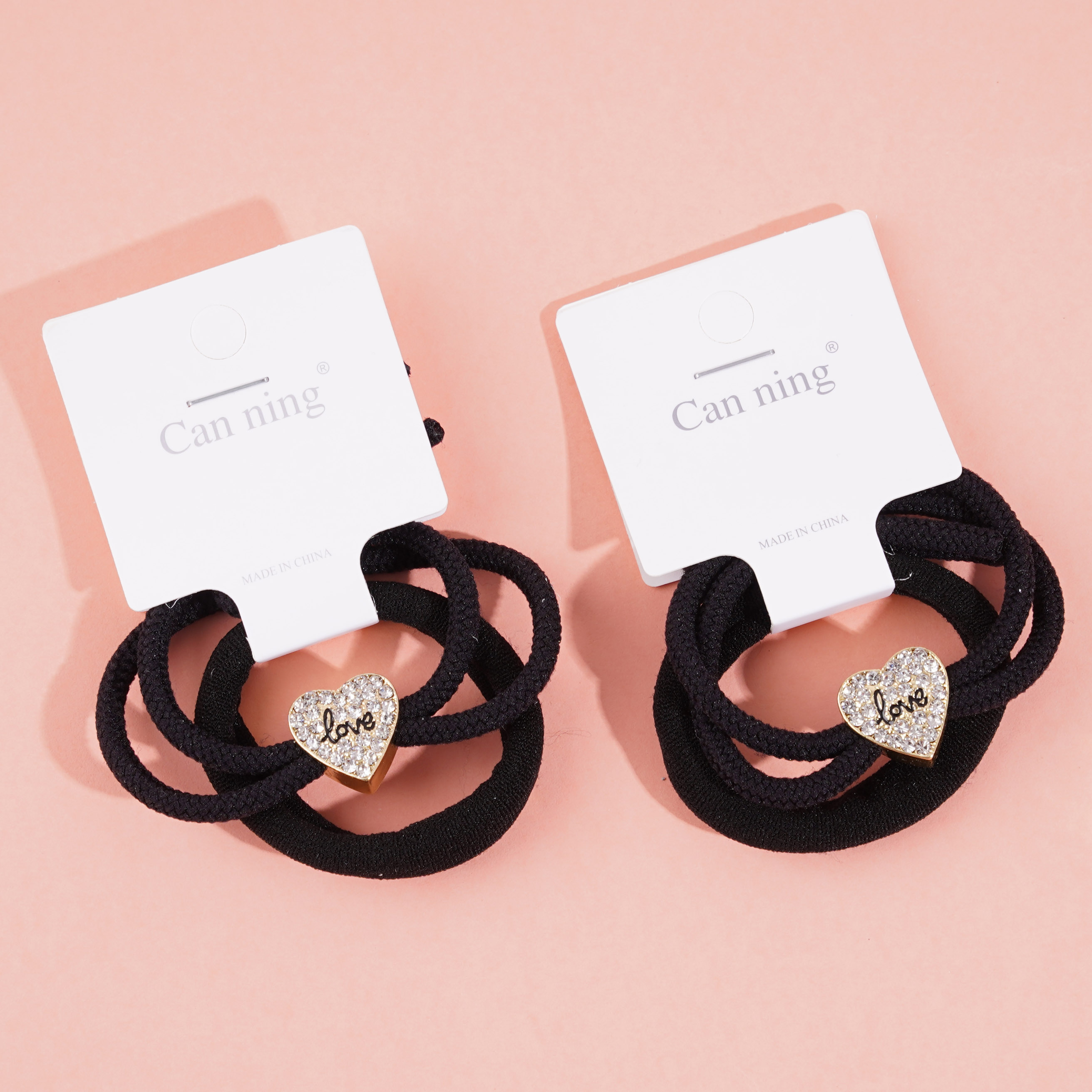 2 heart-shaped diamond boxes containing headbands and rubber bands