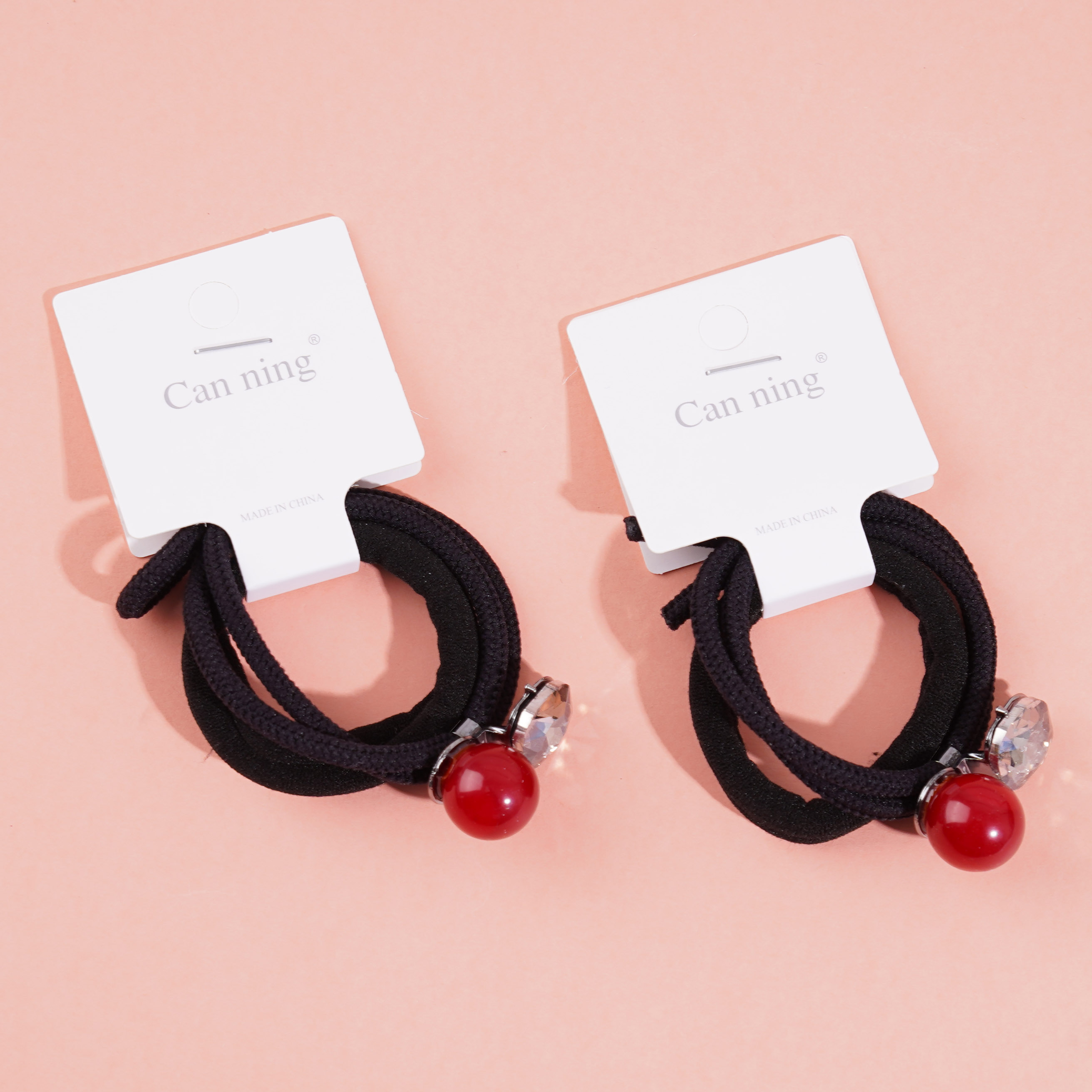 2 red bead-encrusted boxes containing headbands and rubber bands