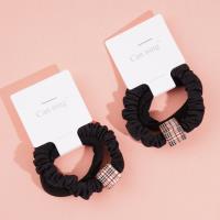 2 élastiques pour cheveux emballés dans une boîte carrée.