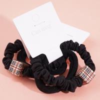 2 élastiques pour cheveux emballés dans une boîte carrée.