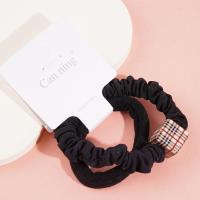 2 élastiques pour cheveux emballés dans une boîte carrée.