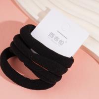 4 élastiques à cheveux avec des embouts en forme de serviette noire.