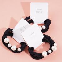 A headband made of three strands of hair with four pearls attached as decorations