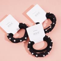 A set of three pearl sausage-shaped hair ties with a combined headband and elastic band design