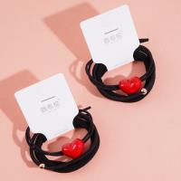 3 élastiques pour cheveux avec des pendants en forme de cœur rouge.
