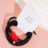 3 élastiques pour cheveux avec des pendants en forme de cœur rouge.