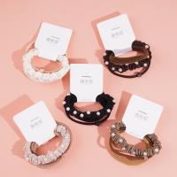 A set of three brown pearl hairbands with a headband and elastic bands