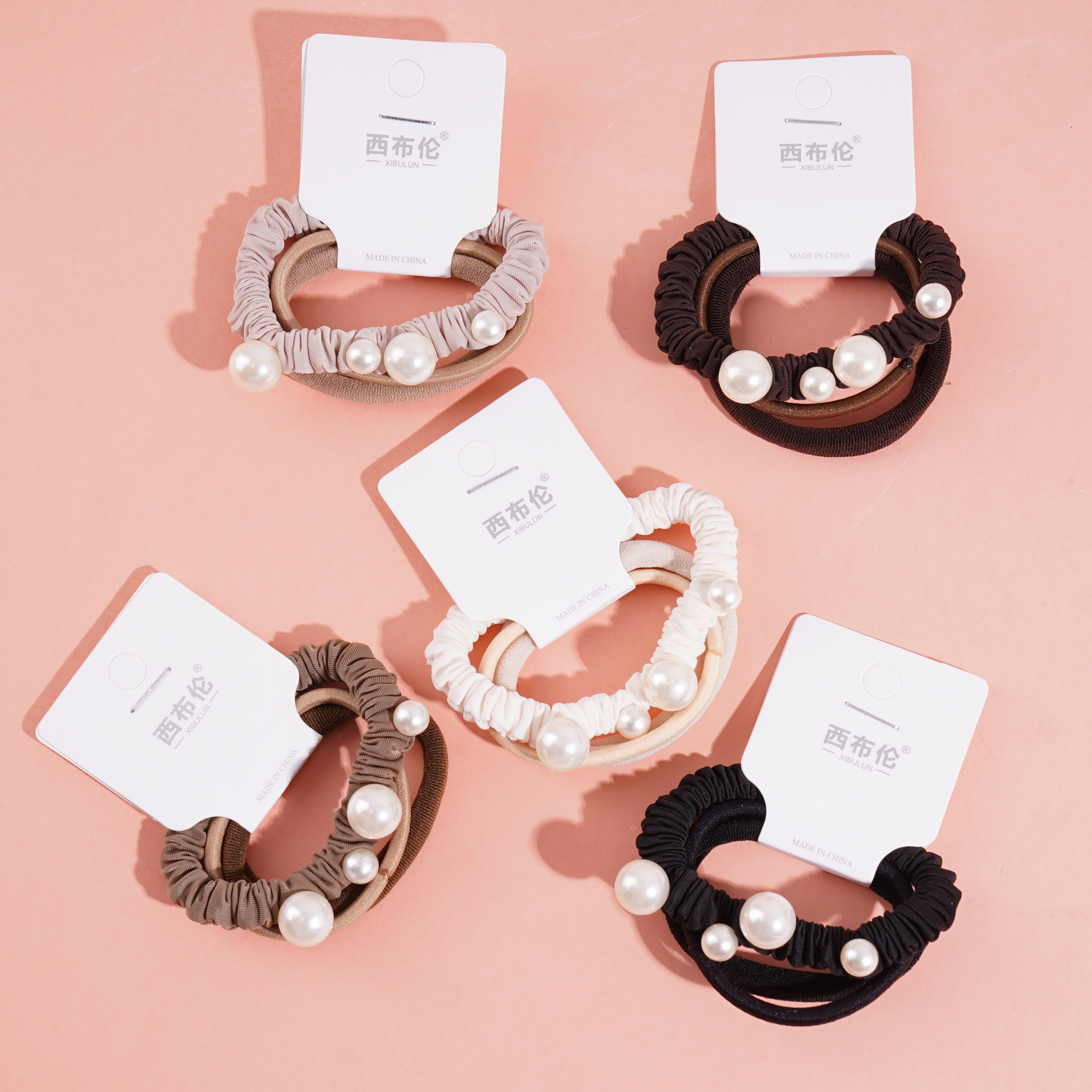 A headband made of three brown strands and four pearl beads, combined with elastic bands