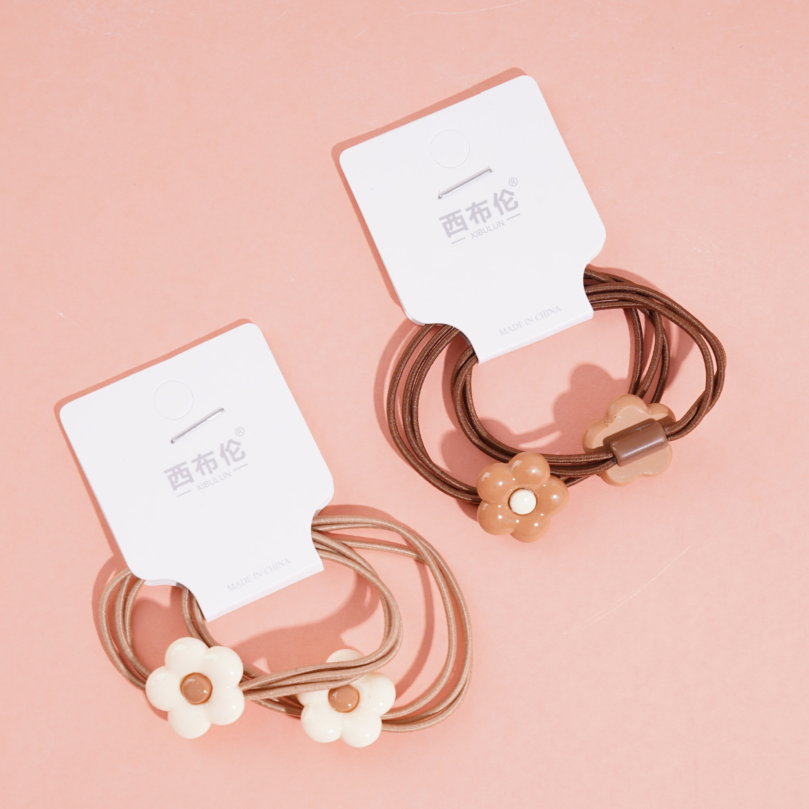 2 flower-patterned brown headbands and hair ties