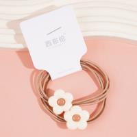 2 élastiques à cheveux de couleur café avec des fleurs dessus.