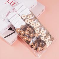 2 élastiques à cheveux de couleur café avec des fleurs dessus.