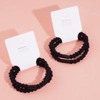 2 black ponytail elastics with a bow-shaped design