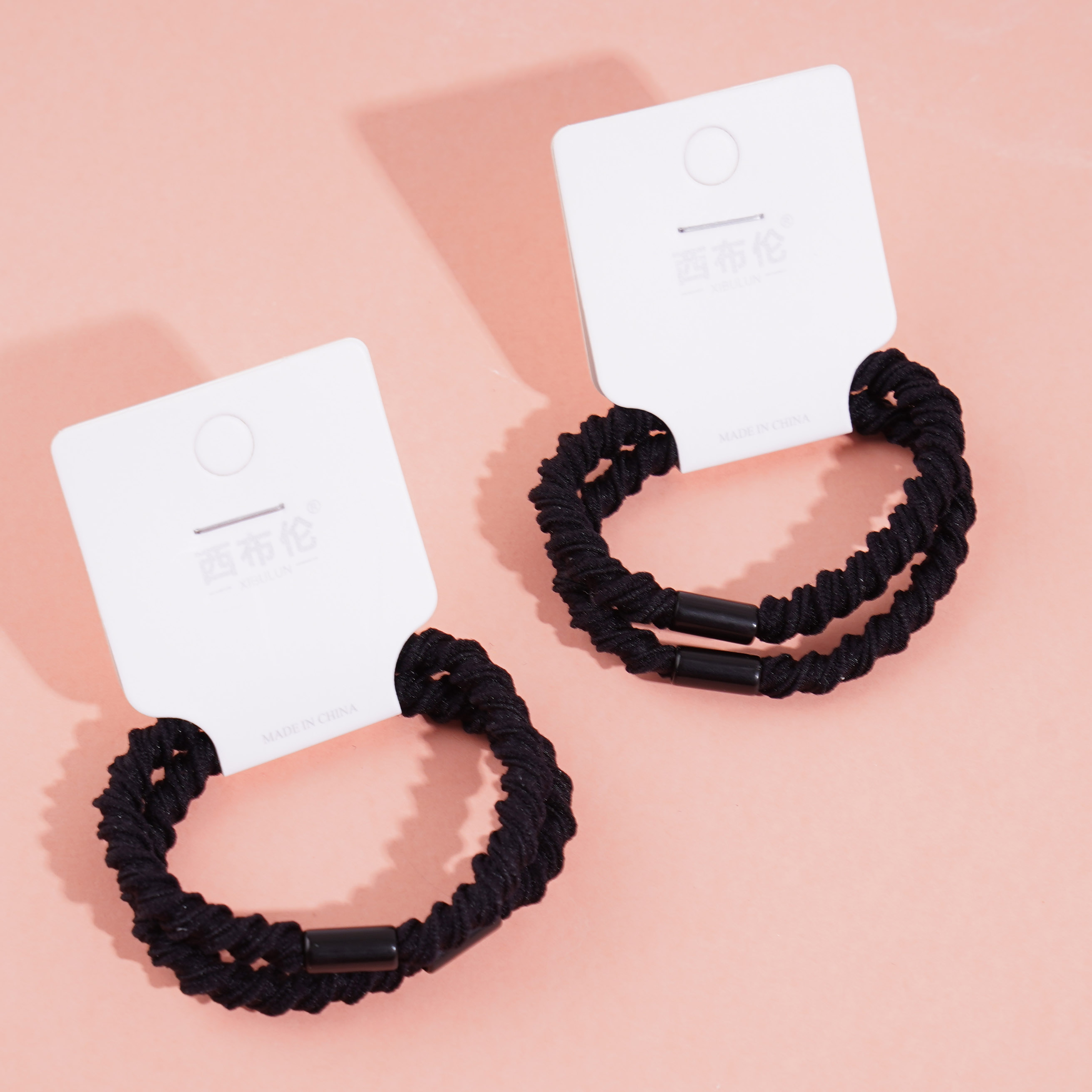 2 black ponytail elastics with a bow-shaped design